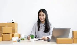 Mulher sorridente depois de ter embalado suas encomendas internacionais