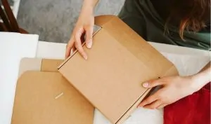 Pessoa embalando uma caixa para uma encomenda internacional