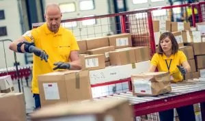 Homem e mulher fazendo os processos de fiscalização de encomendas internacionais